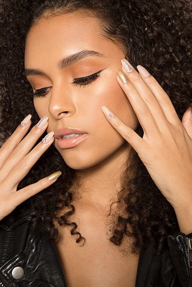 a fierce woman looking at her right bottom with her fingers in front of her cheek showing her artificial nails from Ardell