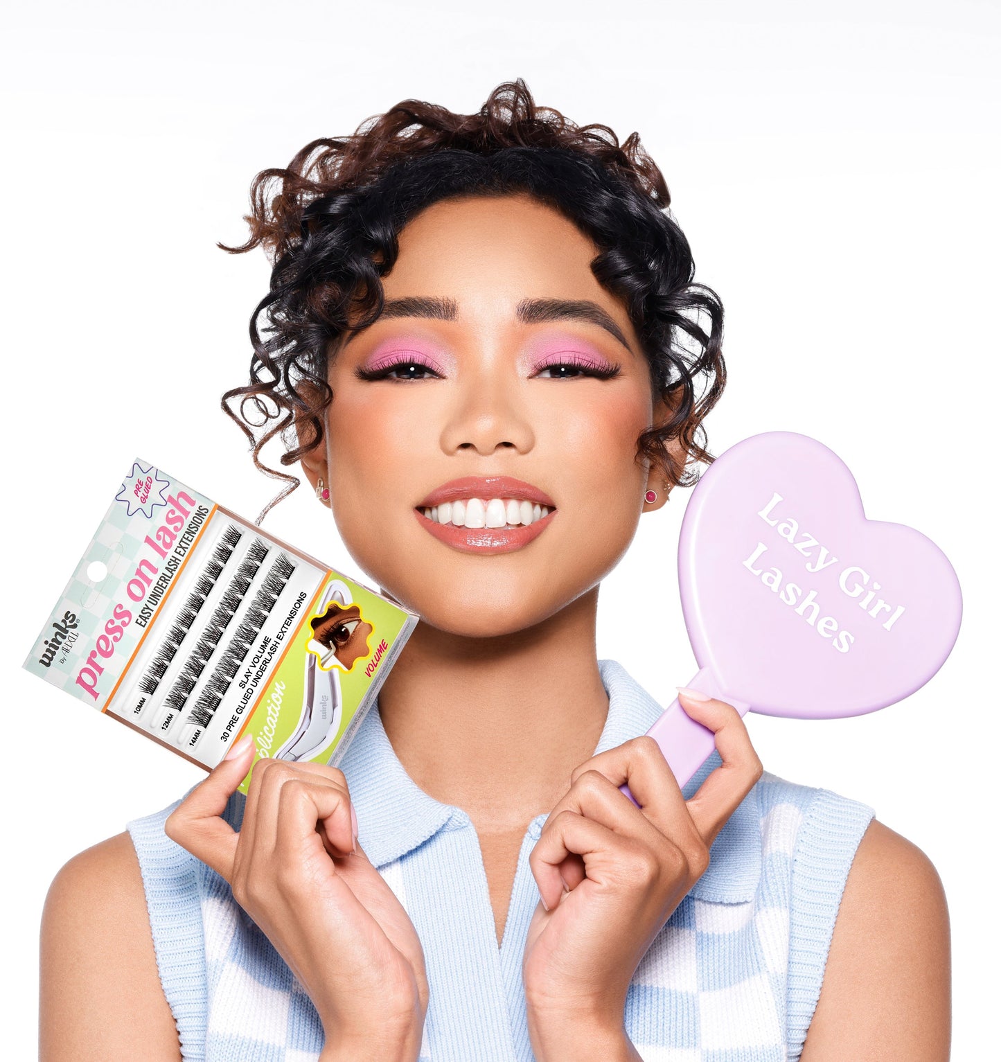 Woman holding Winks press on volume eyelashes packaging and a heart-shaped mirror with text 'Lazy Girl Lashes'.