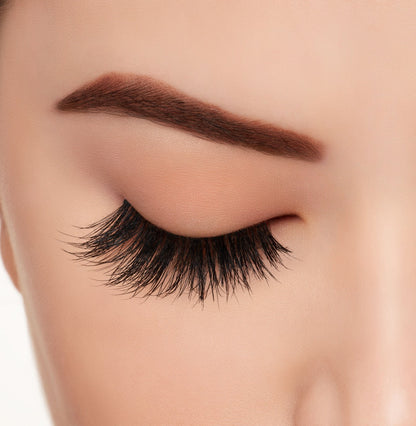 Closer look of a model's closed right eye wearing Ardell Wispies 705 false lashes